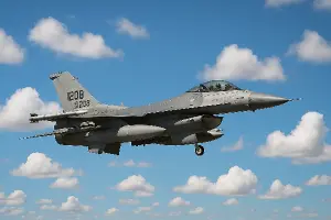 Letící reálná stíhačka F16 na nebi, tj. modré pozadí s bílými mraky.
