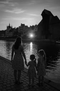 Černobílá fotografie přístavu v Gdaňsku, jedna žena a dvě malé dcery, v pruhovaných šatech, při západu slunce