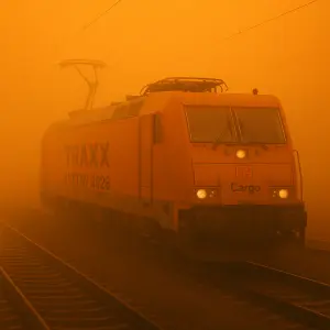 Vytvoř obrázek traxxové květen 2026 s oranžovou mlhou všude kolem