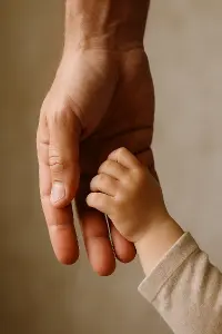 Ruka tatínka, kterou drží dětská ruka