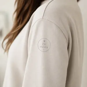 Menší kulaté logo na rameno, s jasným a jemnějším nápisem ,,Psí máma" ve světle šedém odstínu.