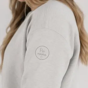 Menší kulaté logo na rameno, s jasným a jemnějším nápisem ,,Psí máma" ve světle šedém odstínu.