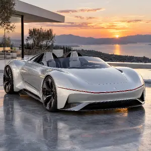 Futuristický nízký elektrický dvoumístný roadster, perleťově bílý a stříbrný lesklý lak, skryté světlomety, tenký červen