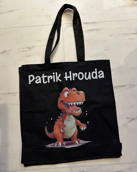 Černá taška s barevným dinosaurem a jménem Patrik Hrouda