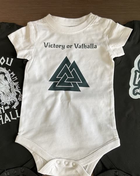 Bílé dětské body s nápisem Victory or Valhalla a symbolem trojúhelníků